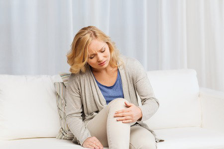 woman holding hurting leg