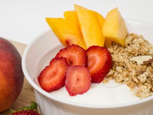 bowl of yogurt with fruit and granola on top