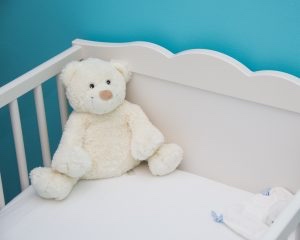 crib with white teddy bear and blue room