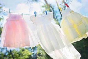 little girls dresses hanging on a clothes line in the sun