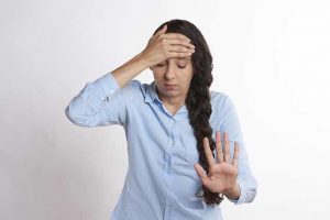 girl with long hair holding her head