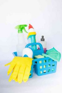 basket of cleaning supplies gloves spray bottles