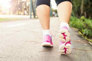 woman walking with pink tennis shoes