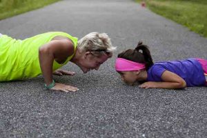 woman and child doing push ups outside